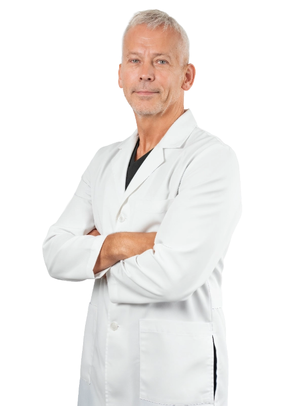 Professional headshot of Dr. Tyson wearing a white lab coat, smiling at the camera against a black background. This is a standard medical professional portrait used for clinic or practice identification.